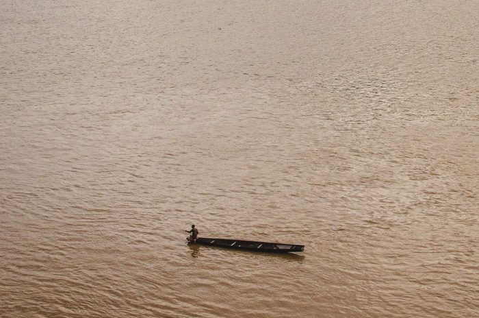 fishermen on a boat on the maroon mekong river in Laos taken by Milie Del