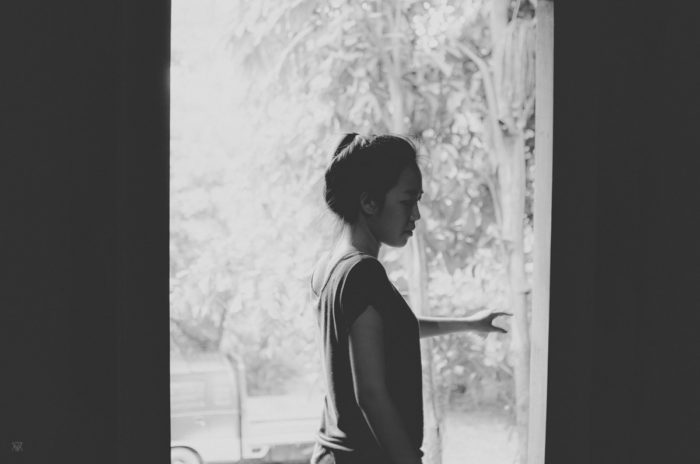 Black and white portrait of young girl in her home in Vientiane in Laos taken by Milie Del
