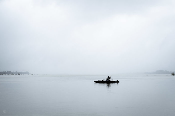 fishermen on a boat on the calm mekong river at Twilight in Laos taken by Milie Del