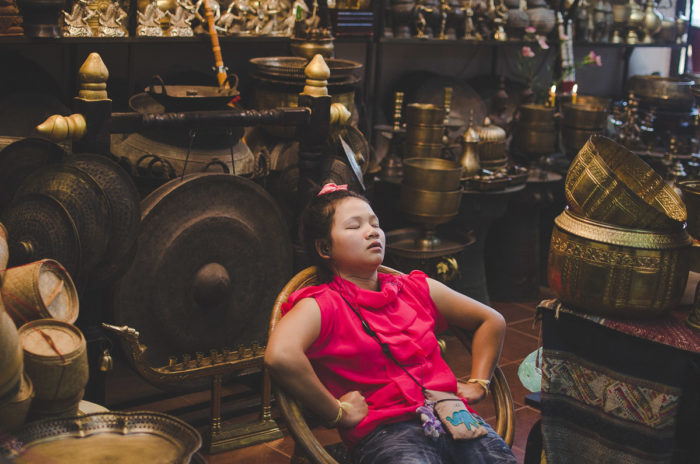 Portrait of a young woman sleeping at her shop in the market in Vientiane in Laos taken by Milie Del