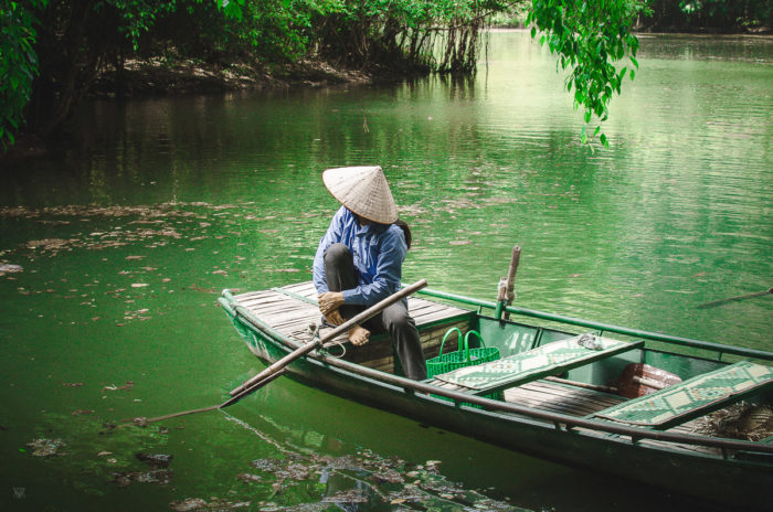 beautiful portrait of a woman waiting and green waters at Tam Coc Vietnam taken by Milie Del
