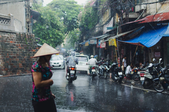 girl running under the rain in Hanoi Vietnam taken by Milie Del