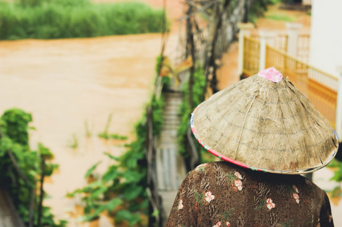 Lao hat and woman crossing a brigde over the mekong river in Laos taken by Milie Del