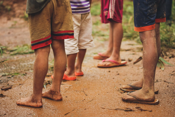 Hmong Children's foot in the mud on the road to Luang prabang in Laos taken by Milie Del