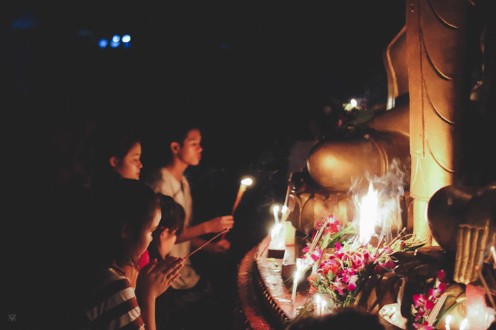 girl praying during a buddhist ceremony in vientiane in Laos taken by Milie Del