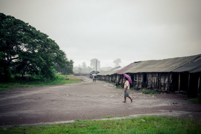 Man crossing the road near the salt factory under the rain near Vientiane Laos taken by Milie Del