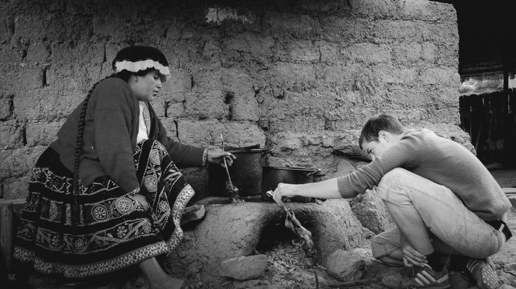 Photography of a Peruvian woman teaching my bother how to cook Guinea pig in Peru