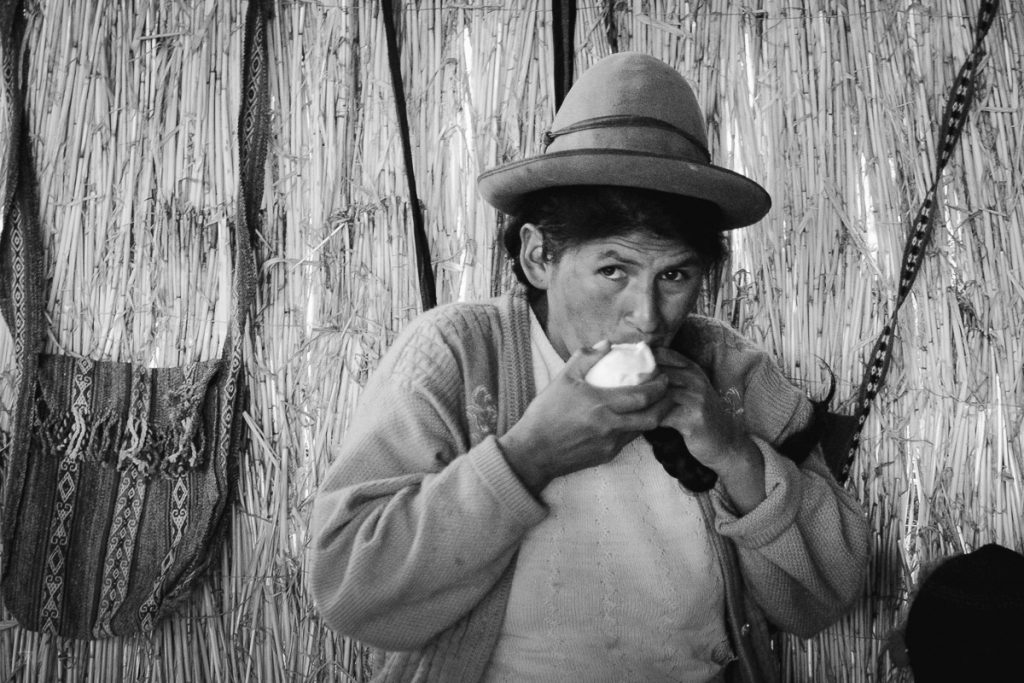 Portrait in black and white of a woman eating in the community amaru village in Peru taken by milie del
