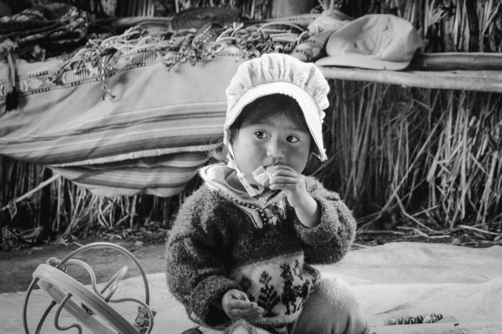 Portrait in black and white of a little girl playing in the community amaru village taken by milie del