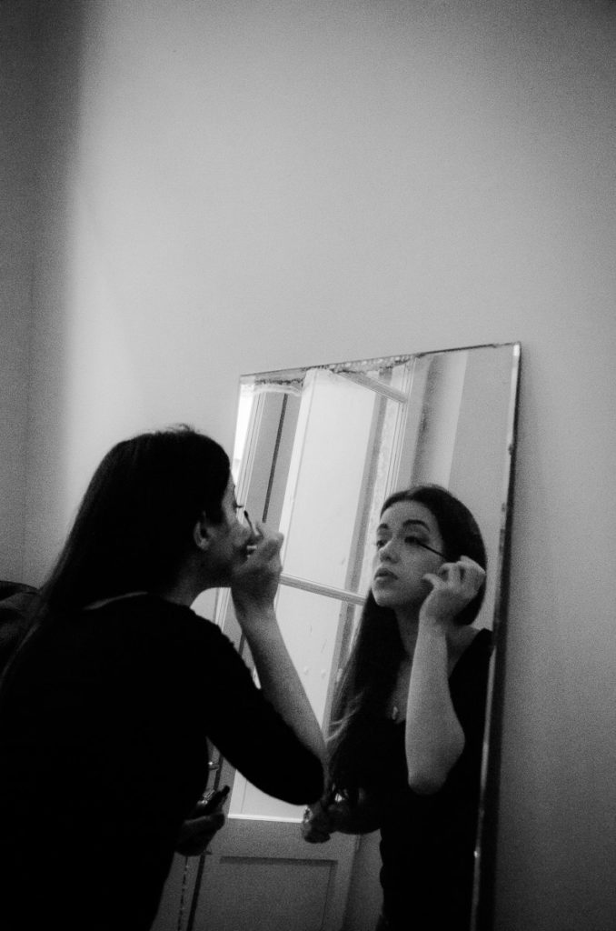 Woman facing mirror make up editorial shoot