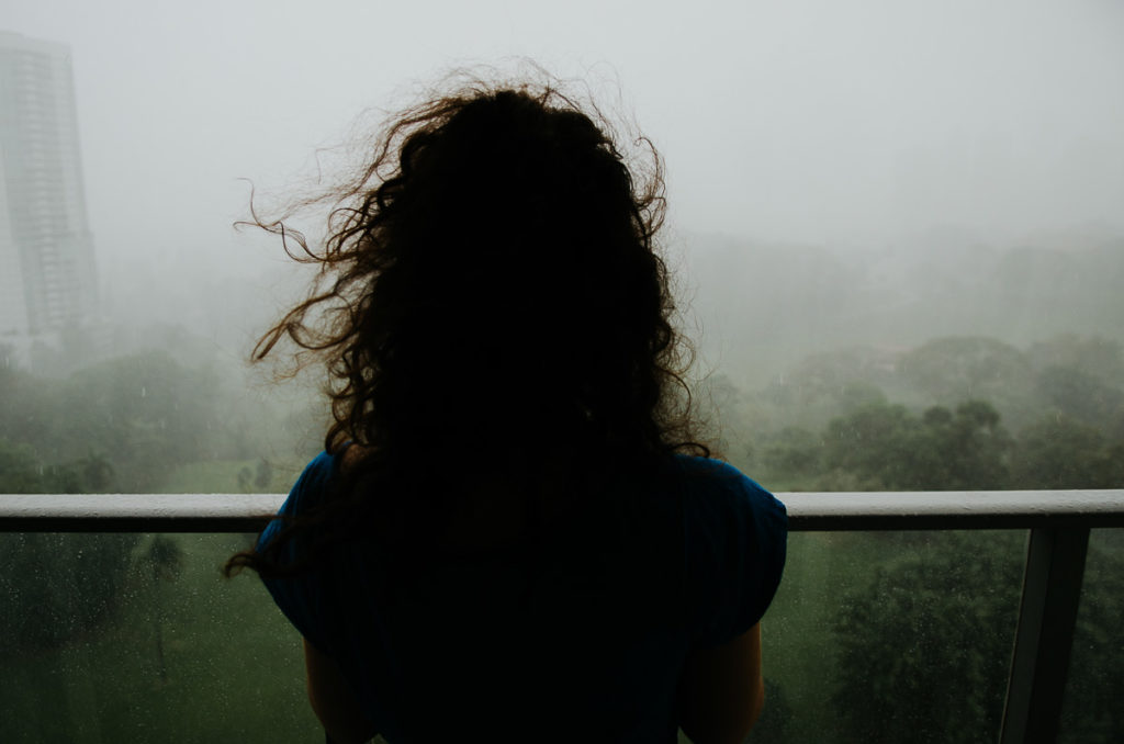 cheveux vent femme regardant pluie tropical immeuble