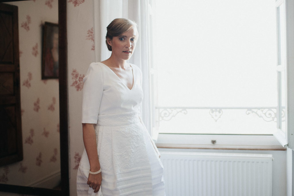 beautiful bride standing at the window soft light