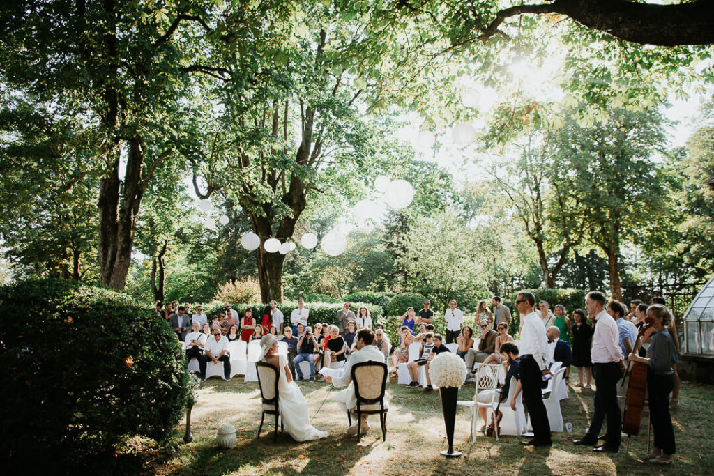 Bride and groom during the outdoor ceremony surrounded by friends and families