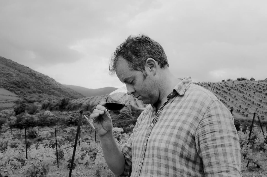 Tom Hills tasting wine in the vineyard