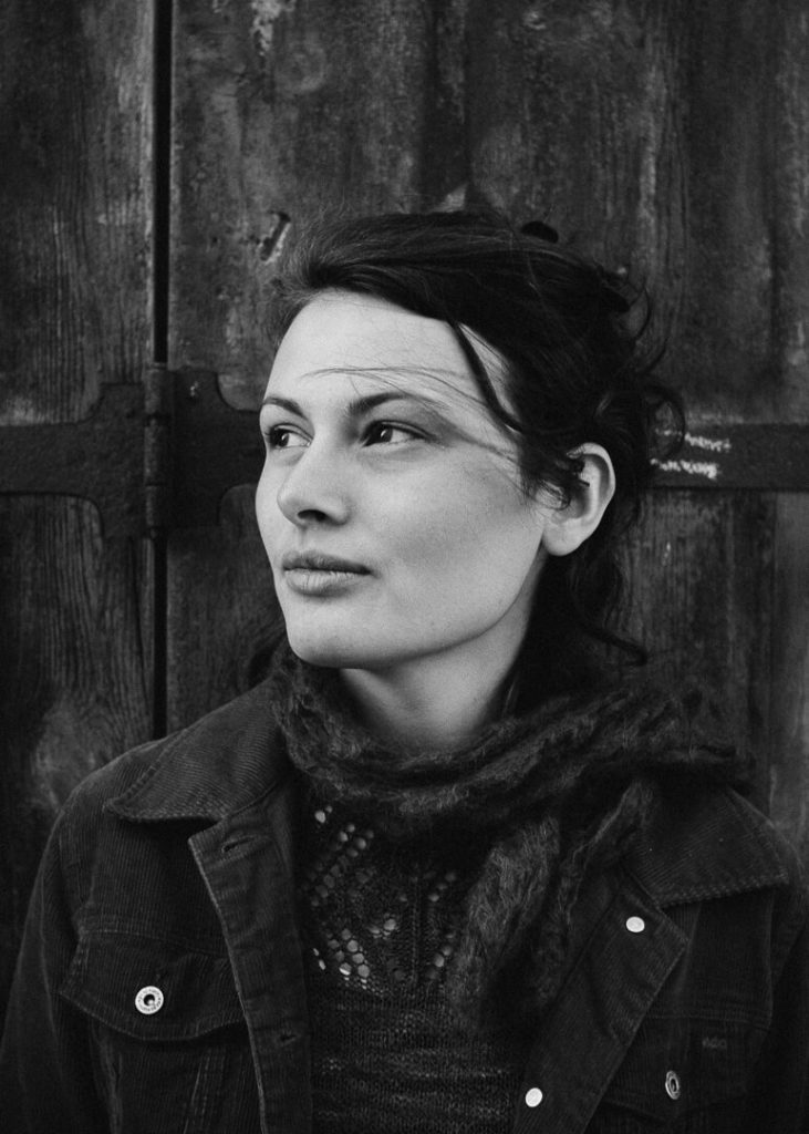 portrait en noir et blanc Manon Gilbert cheveux au vent porte en bois massif