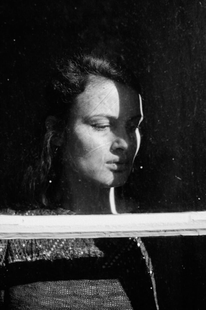 portrait en noir et blanc derrière une fenêtre de Manon Gilbert
