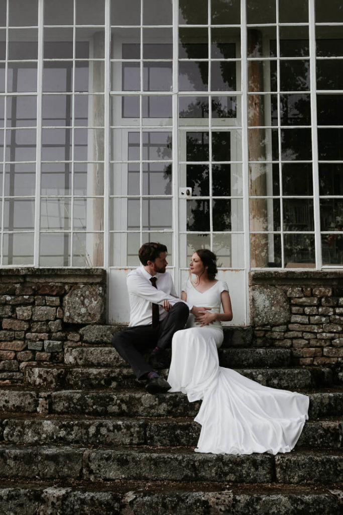 couple posing in front of a greenhouse burgundy