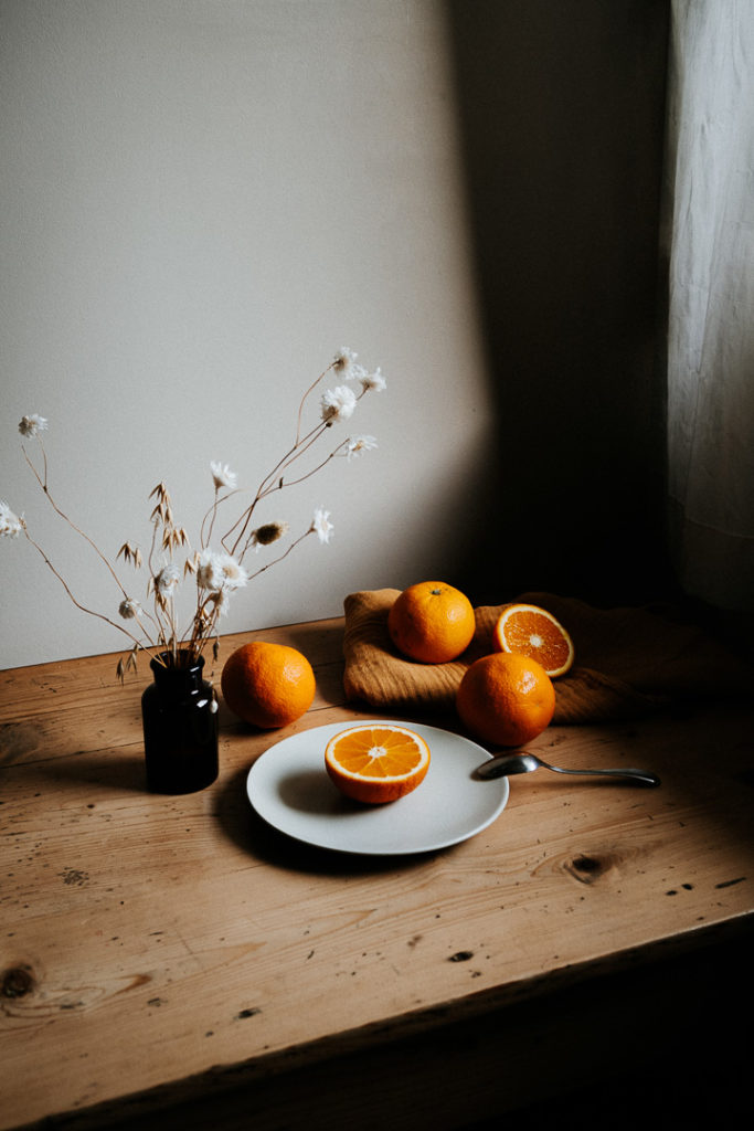 miliedel photographs oranges on a vintage table light and shadows