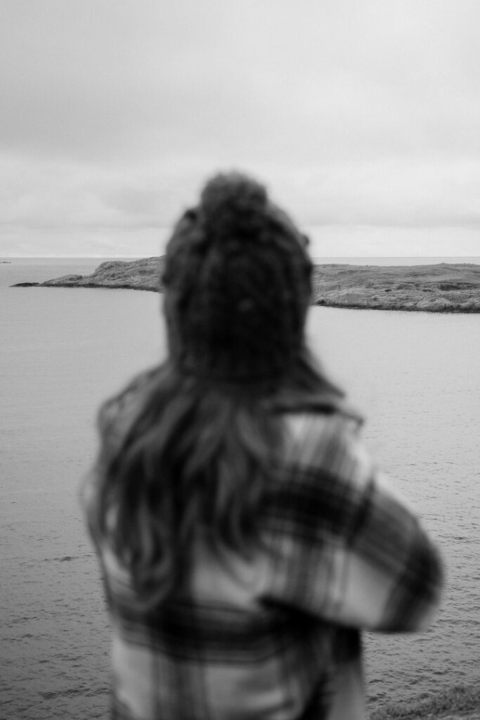 back of a woman facing the ocean